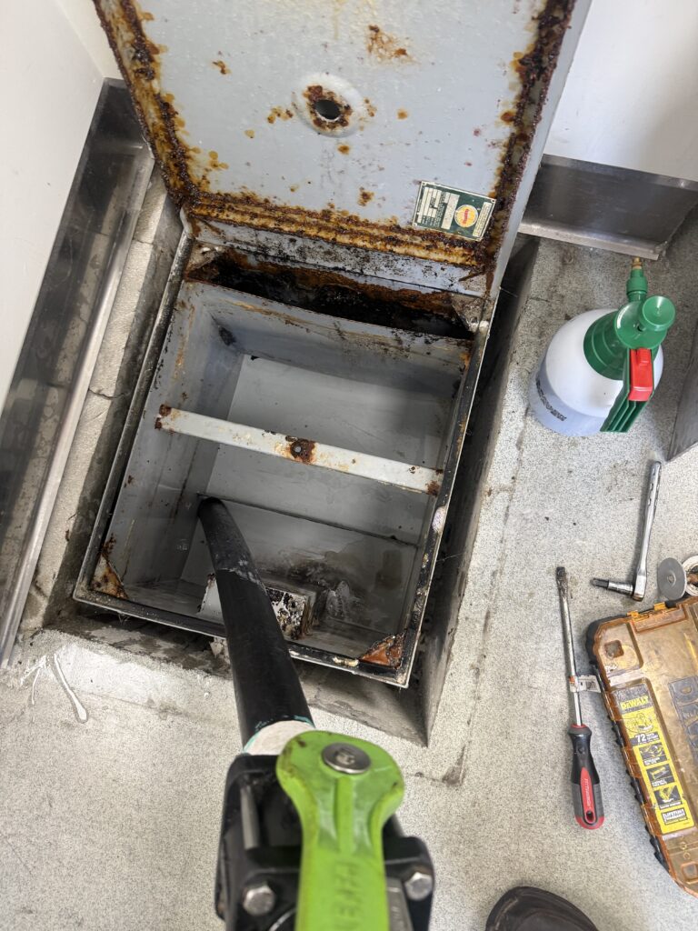 Empty grease trap after professional pumping and cleaning service in Orange County commercial kitchen